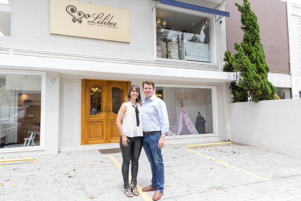 Casal que criou a Lilibee em frente a uma das lojas da primeira franquia especializada em quartos de bebê, criança e itens para a maternidade e primeira infância Léo Barrilari/ Divulgação